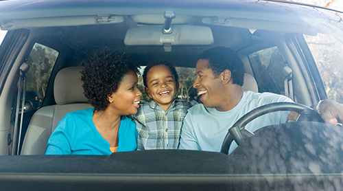 smiling african american family of three inside their vehicle